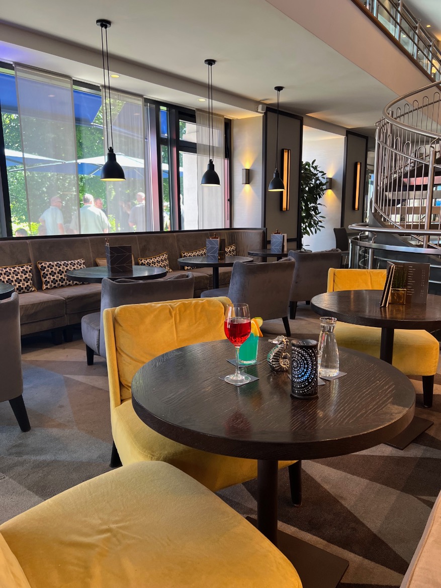 Die Bar des Seaside Park Hotels mit runden Tischen und warmem Licht